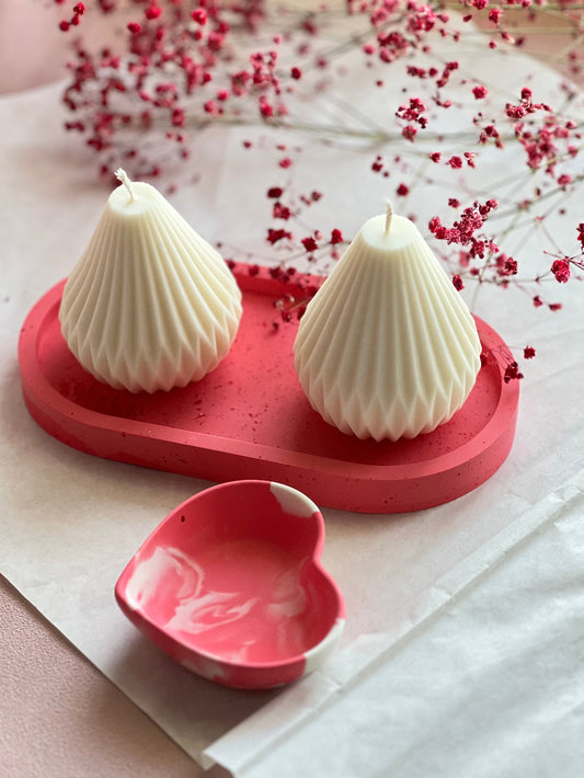 Two candles from natural wax on a pink oval tray